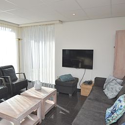 Gemuetliches Wohnzimmer des Ferienhauses 't Hoogelandt 36, Texel mit bequemer Sitzecke.
