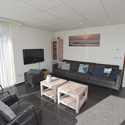 Modernes Wohnzimmer im Ferienhaus 't Hoogelandt 36, De Dennen, Texel mit grossem Sofa.