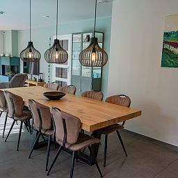 Esszimmer mit Holztisch und stimmungsvoller Beleuchtung im Ferienhaus de Parel 174, De Dennen, Texel.