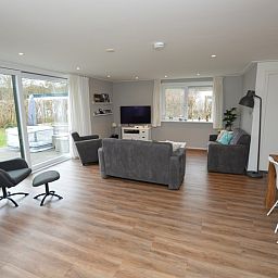 Geraeumiges Wohnzimmer des Ferienhauses de Parel 168 in De Dennen, Texel, mit moderner Einrichtung und viel natuerlichem Licht.