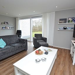 Gemuetliches Wohnzimmer mit Blick auf den Garten im Ferienhaus de Parel 168, De Dennen, Texel, ideal fuer die Familie.