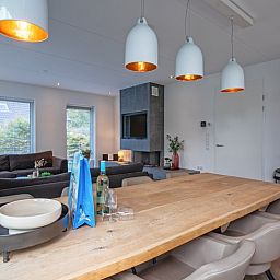 Stilvolles Esszimmer in der Villa Bloem en Bos, Bungalowpark 't Hoogelandt, De Dennen, Texel, mit moderner Beleuchtung und einem grossen Holztisch.