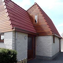 Aussenansicht des Ferienhauses Gortersmient 326 in De Dennen, Texel, mit charmanter Architektur und roten Dachziegeln.