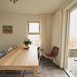 Essecke im Ferienhaus De Mispel, De Dennen, Texel mit grossen Fenstern und viel Licht.