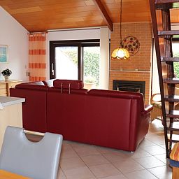 Gemuetliches Wohnzimmer mit grossen Fenstern im Ferienhaus Gortersmient 300, De Dennen, Texel. Geniessen Sie die Aussicht und die Natur auf den Waddeninseln.