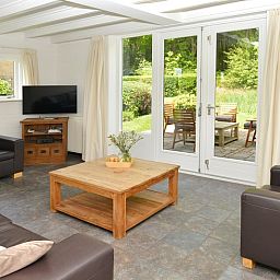 Gezellige woonkamer van vakantiehuis Turel in De Dennen, Texel met uitzicht op terras.