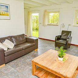 Comfortabele zitruimte in vakantiehuis Turel, De Dennen, Texel met tuinzicht.