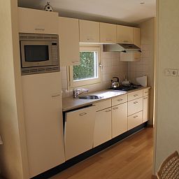 Moderne keuken en gezellige woonkamer in vakantiehuis Vakantiepark de Bremakker, Heitje 166, De Dennen, Texel, omgeven door natuur.