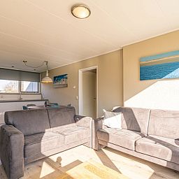 Stilvolles Wohnzimmer im Ferienhaus De Parel 166, Bungalowpark De Parel, Texel. Raum fuer Entspannung und Gemuetlichkeit.