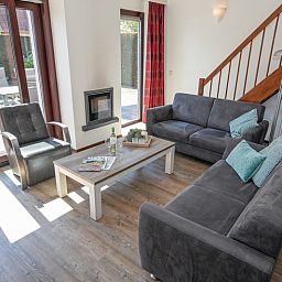 Comfortabele zithoek in Vakantiehuis Gortersmient 328, De Dennen, Texel met uitzicht op de tuin.