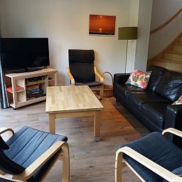 Gemuetliches Wohnzimmer in Bollenveld - de Iris, Ferienhaus De Dennen, Texel mit bequemer Sitzecke und Fernseher.