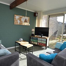 Lichtovergoten woonkamer met uitzicht op de tuin in Bungalow Verste Coogh 66, De Dennen, Texel.