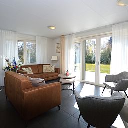 Helles Wohnzimmer des Ferienhauses de Parel 190 in De Dennen, Texel mit gemuetlicher Sitzecke.