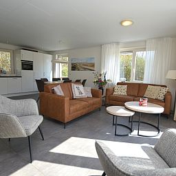 Offenes Wohnzimmer und Kueche im Ferienhaus de Parel 190, De Dennen, Texel mit moderner Einrichtung.