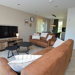 Modernes Wohnzimmer im Bungalow 't Hoogelandt 58, Texel, mit bequemen Sofas und stilvollen Moebeln.