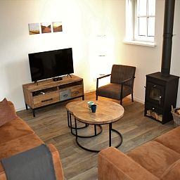 Cozy living room with wood stove in Golden Raand vacation home, Texel.
