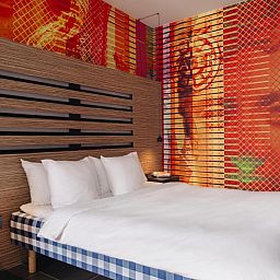 Moderne slaapkamer met kleurrijke muur in Designhotel Maastricht, Limburg.