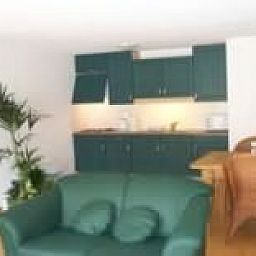 Gezellige binnenruimte van De Zandbult in Oost-Vlieland, Vlieland, met een groene keuken en comfortabele zithoek op de Waddeneilanden.