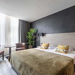 Comfortabele tweepersoonskamer in Hotel Milano, Rotterdam, vakantieappartement met stijlvolle inrichting en veel daglicht.
