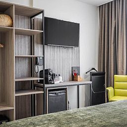 Praktische werkruimte in Hotel Milano, vakantieappartement in Rotterdam, met bureau, tv en opbergruimte.