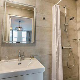 Modernes Badezimmer im Hotel Orion, Ferienwohnung in Rotterdam, Suedholland mit Dusche und Waschbecken.