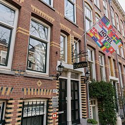Aussenansicht des Hotels Orion, Ferienwohnung in Rotterdam, Suedholland, mit Fahnen und Backsteinfassade.