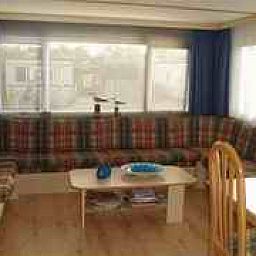 Gemtliches Interieur des Mobilheims Achaa in Formerum, Terschelling, mit bequemer Sitzecke und viel Licht.