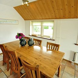 Eetkamer in Appartementenboerderij de Hek Oost, Hoorn, Terschelling met houten tafel en stoelen.