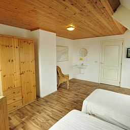 Ruime slaapkamer in Appartementenboerderij de Hek Oost, Hoorn, Terschelling met houten interieur.