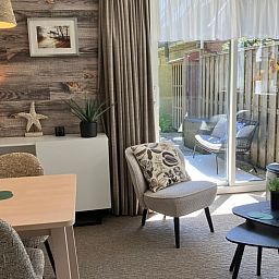Lichte woonkamer van Huisje in Oosterend met uitzicht op het terras, Terschelling, Waddeneilanden.