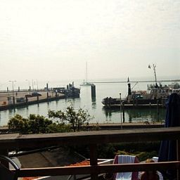 Uitzicht op de haven vanaf het terras van appartement Havenzicht in West, Terschelling, met sfeervolle maritieme omgeving.
