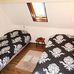 Sfeervolle slaapkamer met twee bedden in appartement Havenzicht, West, Terschelling, perfect voor een goede nachtrust na een dag verkennen.
