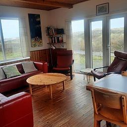 Gezellige woonkamer van Vakantiehuisje in West aan Zee op Terschelling met uitzicht op de duinen en comfortabele zitruimte.