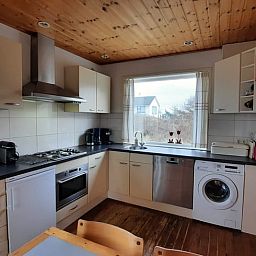 Moderne keuken in Vakantiehuisje in West aan Zee, Terschelling, met uitzicht op de natuur van de Waddeneilanden.