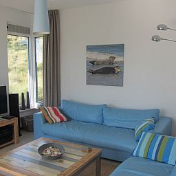 Gezellige woonkamer in Nij Jit vakantiehuis, Midsland aan Zee Terschelling, met comfortabele banken.