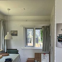 Gemuetlicher Innenbereich des Ferienhauses in Midsland Noord, Terschelling mit Blick auf den Garten, ideal fuer einen entspannten Aufenthalt.