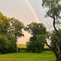 Geniessen Sie den ruhigen Garten und den Regenbogen im Ferienhaus in Midsland Nord, Terschelling, einem idyllischen Ferienhaus auf den Watteninseln.