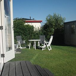 Cozy garden at De Doorloper vacation home in Midsland Noord, Terschelling, ideal for relaxation on the Wadden Islands.