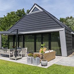 Vakantiehuis Noordhoek in Midsland Noord, Terschelling, met zonnig terras omringd door natuur op de Waddeneilanden.