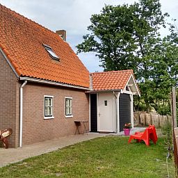 Rustieke buitenkant van vakantiehuis WadsEb.com in Klein Hoorn, Terschelling, omgeven door natuur.