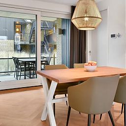 Stijlvolle eetruimte van 4-persoons appartement 4C1 in West-Terschelling, met toegang tot balkon.