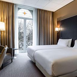 Comfortabele tweepersoonskamer in NH Centre Utrecht Hotel met uitzicht op de stad Utrecht.