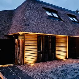 Der abends beleuchtete Eingang des Ferienhauses in Ballum, Ameland, heisst Sie auf den Watteninseln herzlich willkommen.