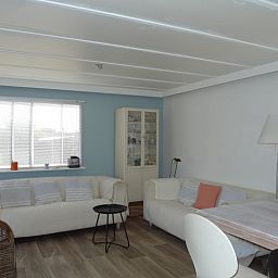 Cozy living room in Eilandgeluk chalet, Ballum, Ameland, with comfortable sofas and lots of natural light on the Wadden Islands.