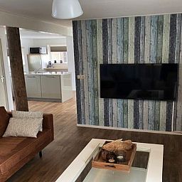 Modernes Wohnzimmer im Ferienhaus Lodge 't Pandje, Ballum, Ameland mit Flachbildfernseher und stilvoller Einrichtung.