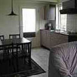 Gemuetlicher Innenbereich von app. Beekema in Buren, Ameland mit moderner Kueche und Essbereich, ideal fuer einen entspannten Aufenthalt.