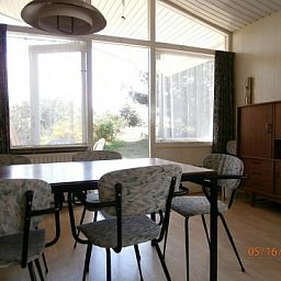 Essecke im Bungalow Dolphin, Buren, Ameland, mit Blick auf den Garten.