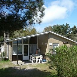 Terrasse des Bungalows Dolphin in Buren, Ameland, mit Gartenmbeln und Natur.