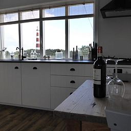 Keuken in Vakantiehuisje in Hollum op Ameland met uitzicht op de vuurtoren, perfect voor kookliefhebbers.