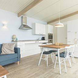 Open keuken en eetgedeelte in Wadden Special vakantiehuis in Hollum, Ameland met eettafel en moderne apparatuur.